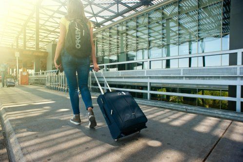 Chica con mochila y maleta andando por el aeropuerto Chica con mochila y maleta andando por el aeropuerto